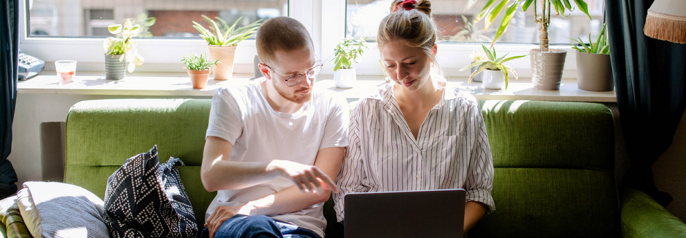 Studierende arbeiten digital Zwei Studierende arbeiten am Laptop, auf einem Sofa sitzend.